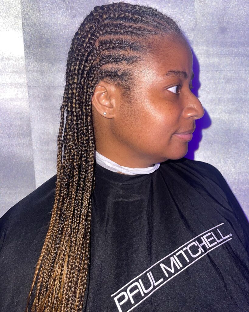 Long honey blonde knotless braids with mixed brown and golden tones.