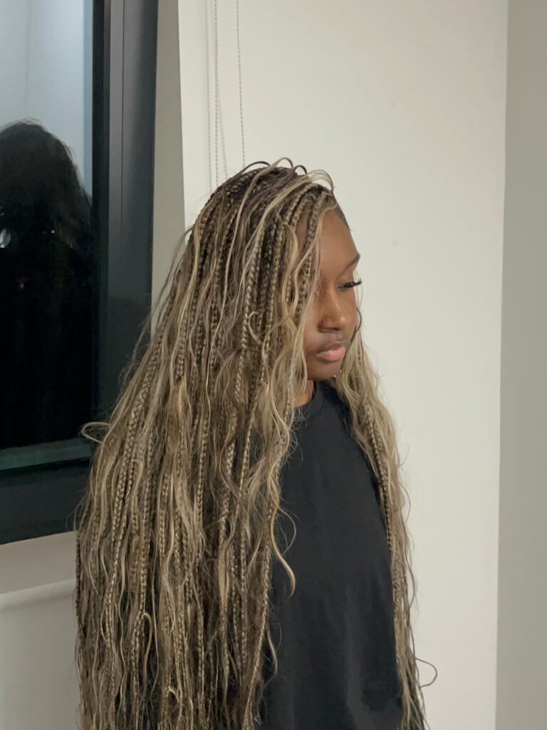 Long ash blonde boho braids with thin plaits and soft wavy strands throughout.