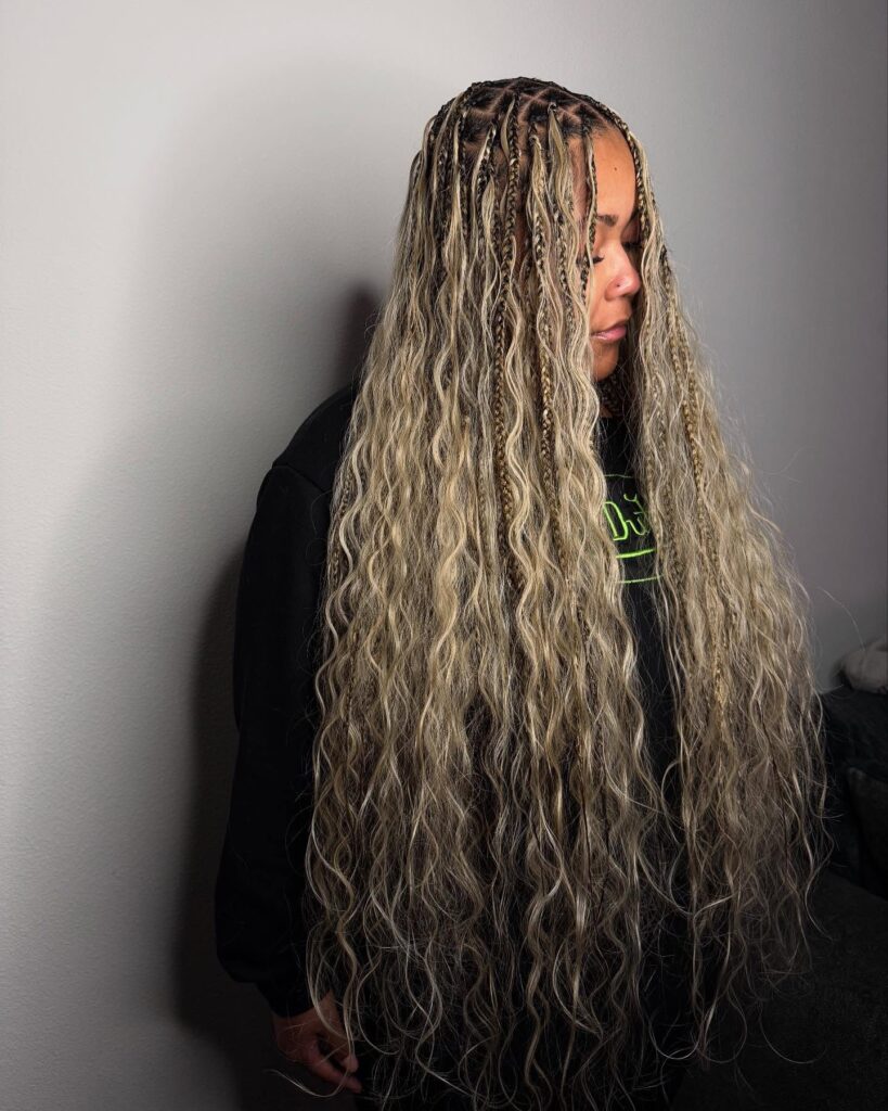 Extra long ash blonde boho braids with mixed textures and soft waves throughout.