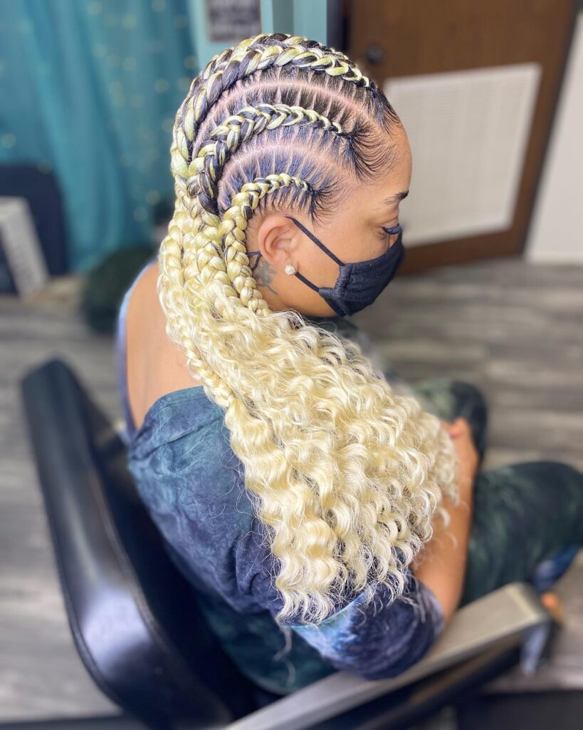 Blonde feed in braids styled back with defined curly ends for a soft finish.