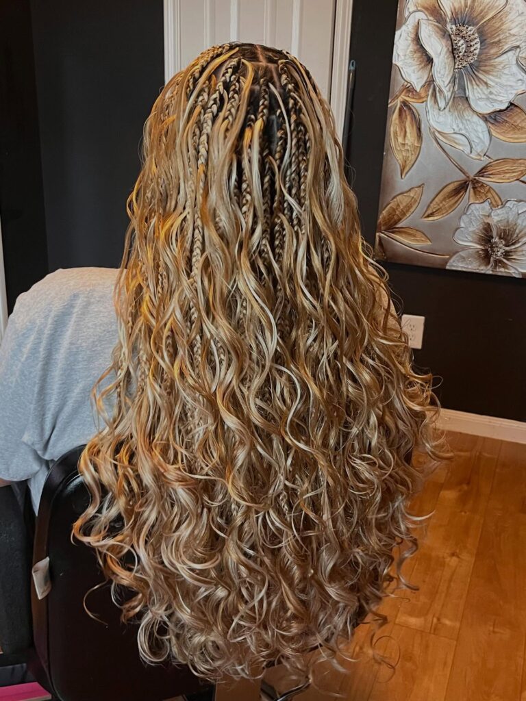 Long honey blonde boho braids with mixed thin plaits and loose waves throughout.