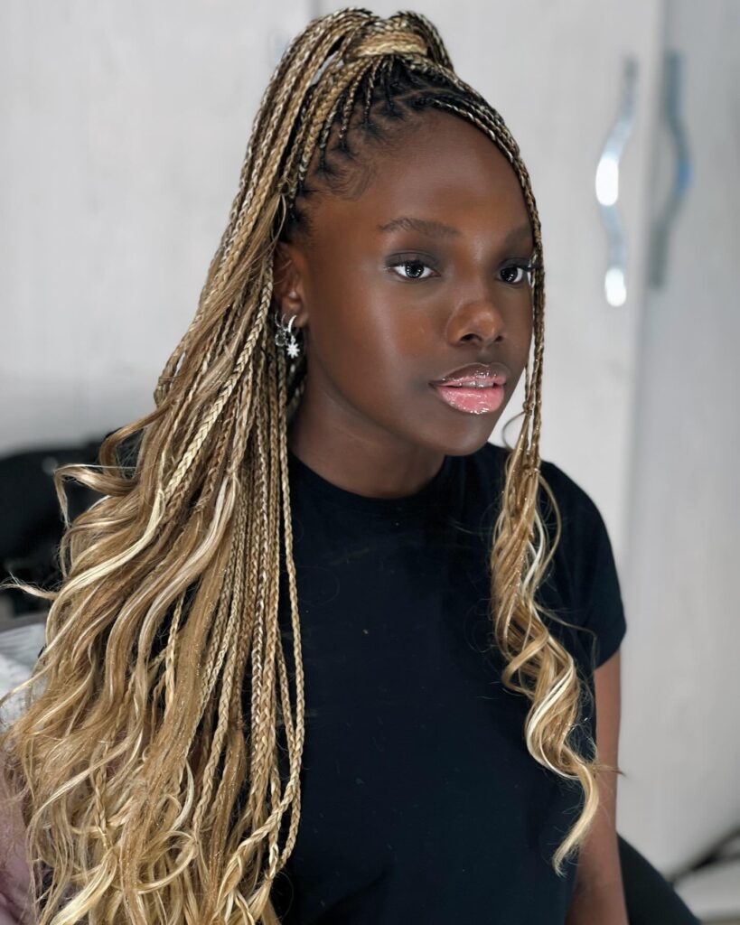 Blonde braided high ponytail with tight braids at the top and long curly ends.