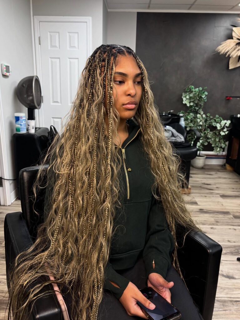 Blonde boho braids with loose wavy strands framing the face and soft layered texture.