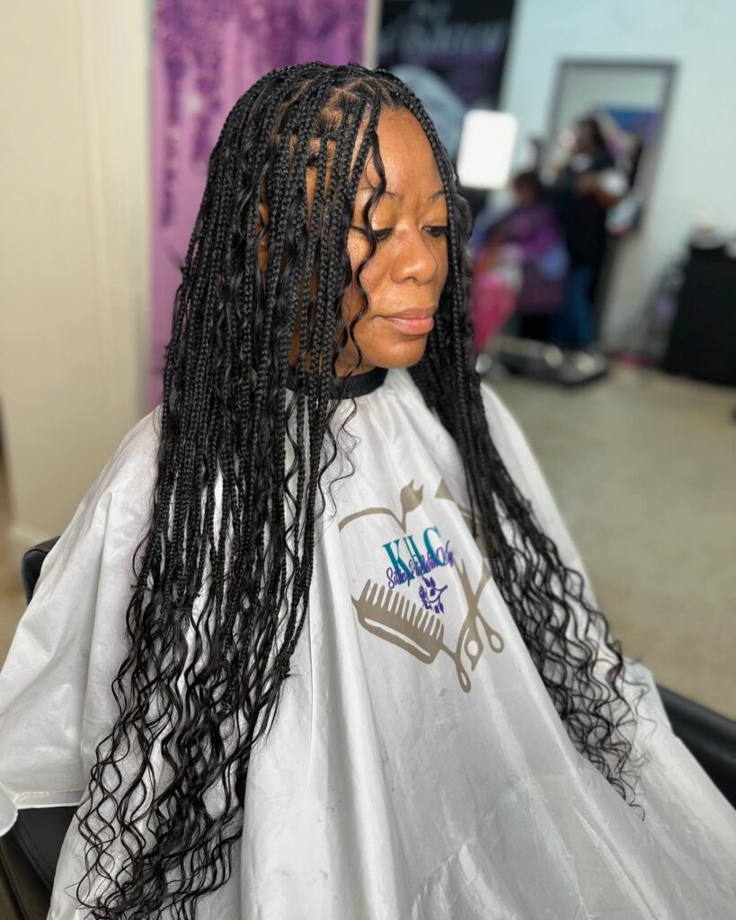 Medium knotless braids with soft loose curls blended throughout the hair.