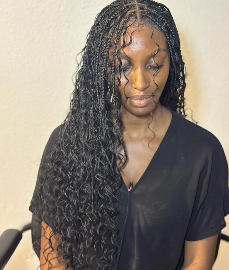 Side parted knotless braids with loose defined curls framing the face and ends.