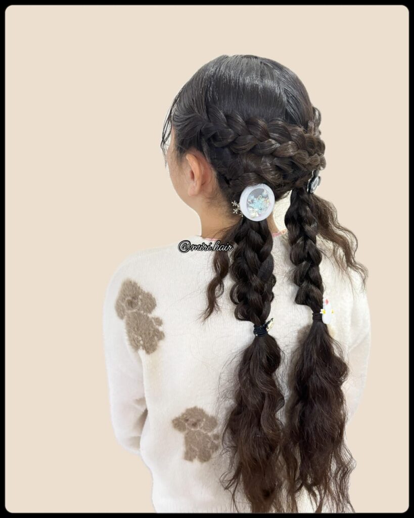 Loose braided pigtails with soft waves and decorative hair clips.