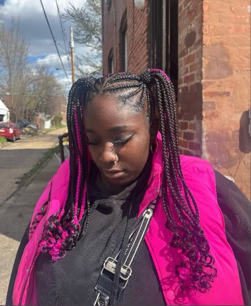 High braided pigtails with black and pink box braids curled at the ends.