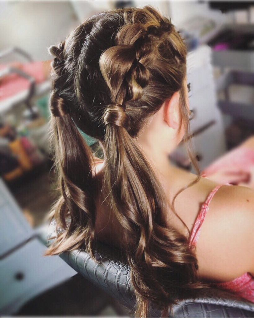 Brunette braided pigtails with curled ponytails and a heart shaped braid detail.
