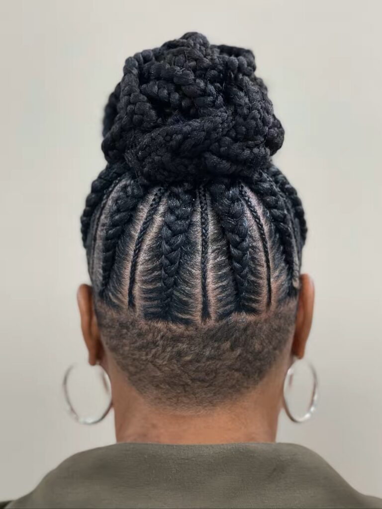Jumbo braided bun hairstyle with thick braids and neat vertical cornrows styled into a large bun.