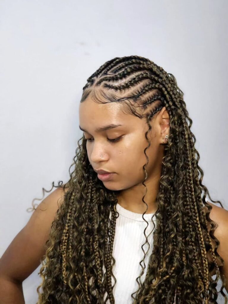 Fulani braids with curly ends and honey brown highlights for a soft textured look.