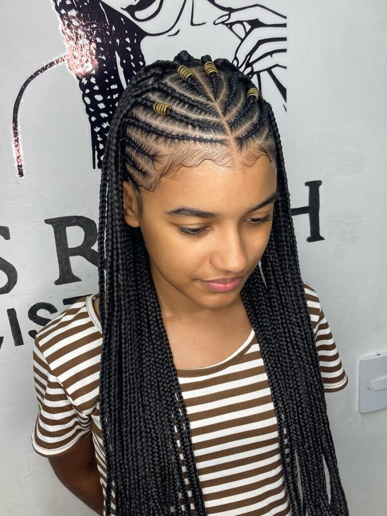 Long Fulani braids with curved cornrows and small gold bead accents.

