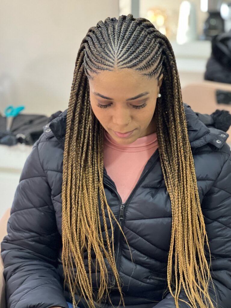 Long Fulani braids with curved cornrows and a dark to blonde ombre effect.