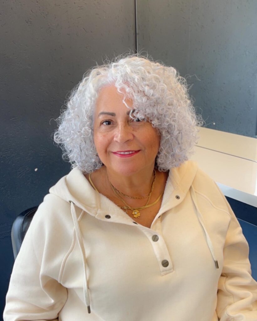 Short white curly bob with soft, rounded shape and light, fluffy curls.