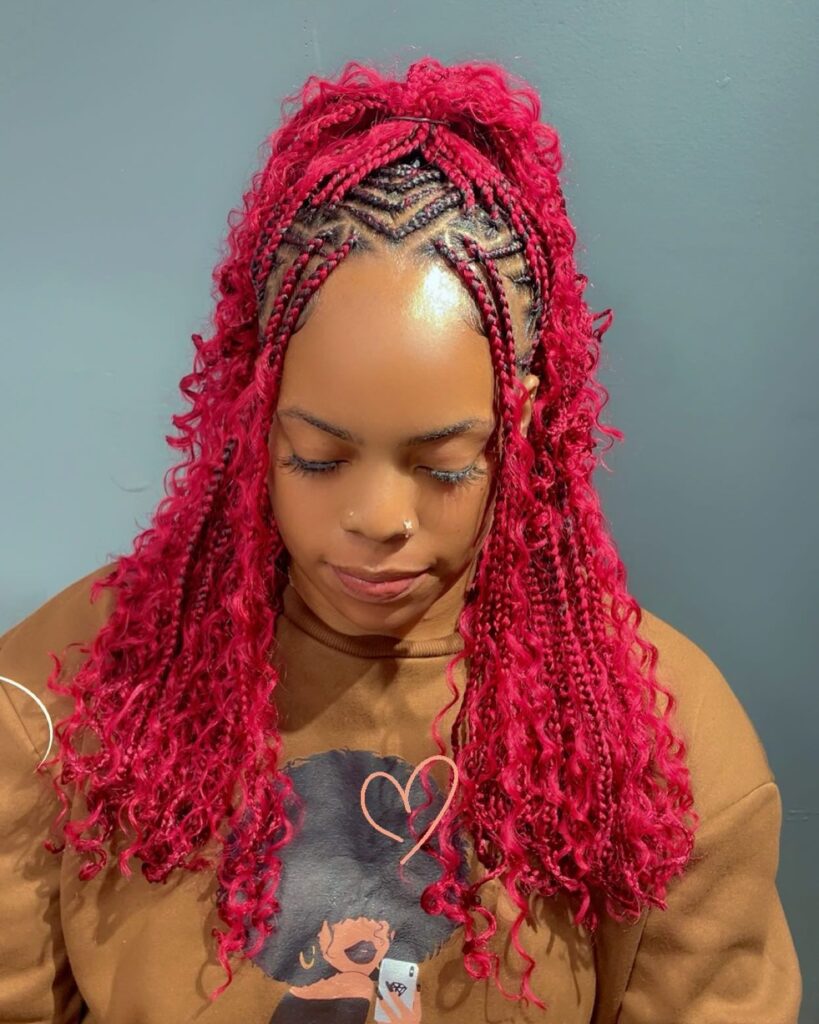 Bright red braids styled half up with detailed cornrows and curly lengths.