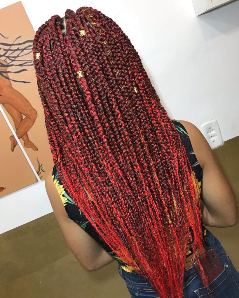 Bright red cornrow braids with clean parting and a sleek finish.