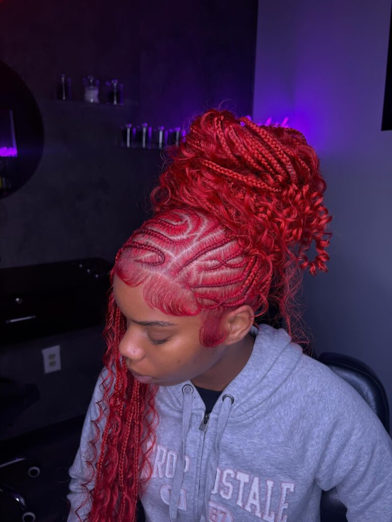 Bright red braided updo with curly ends and detailed scalp patterns.