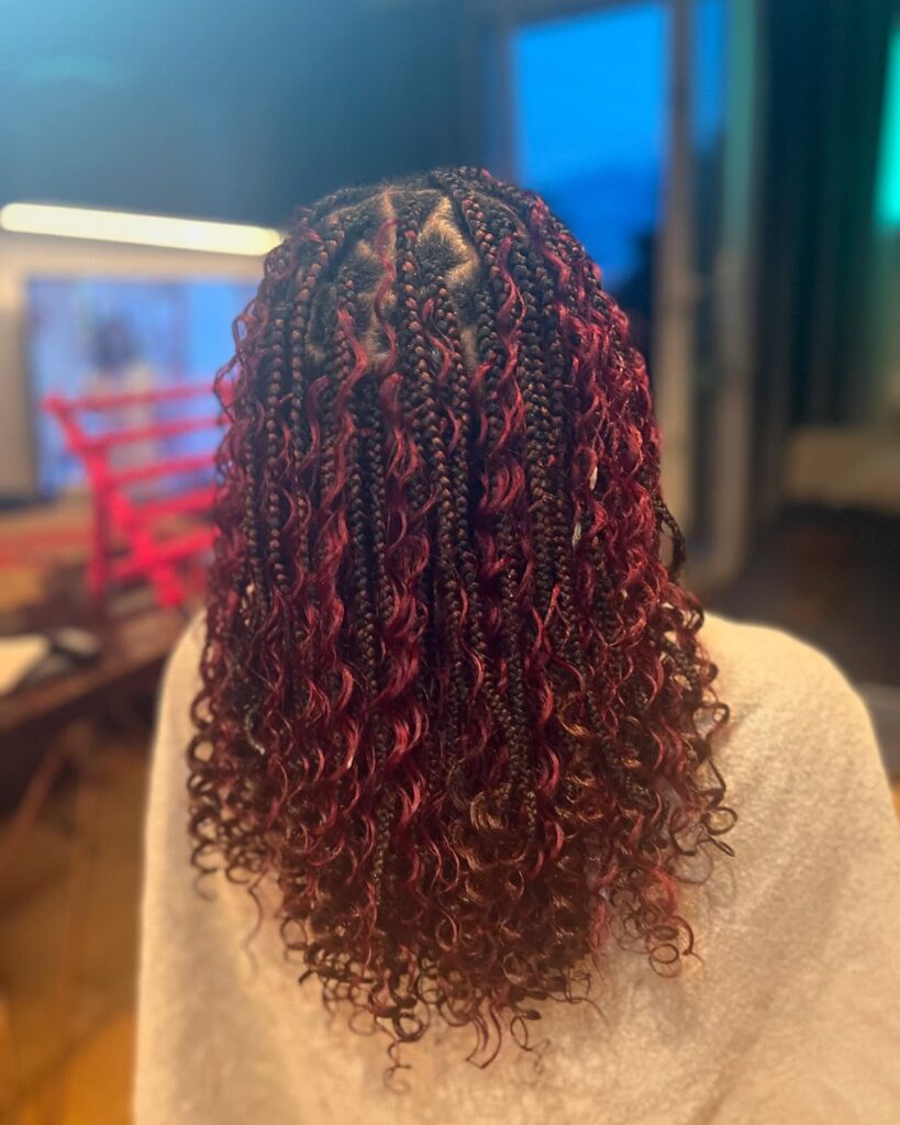 Shoulder length deep red braids with loose curly strands for a boho textured look.
