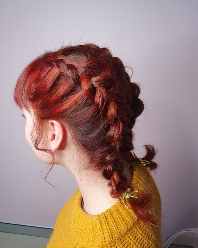 Copper red hair with a braided crown and loose wavy lengths.