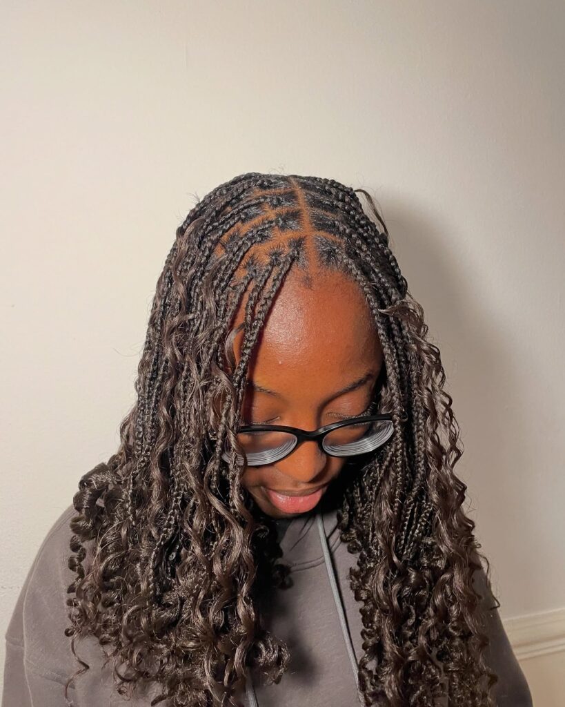 Medium braids with loose defined curls and a soft boho finish.