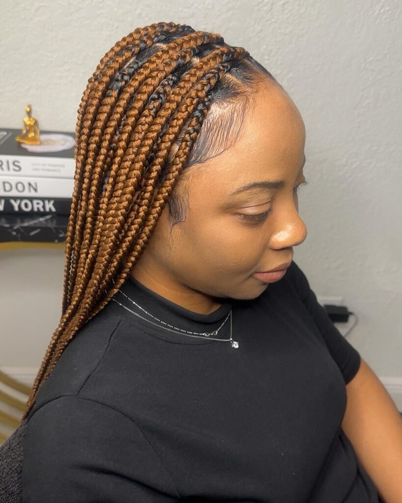Medium length brown knotless braids with a side part and neatly styled baby hairs.