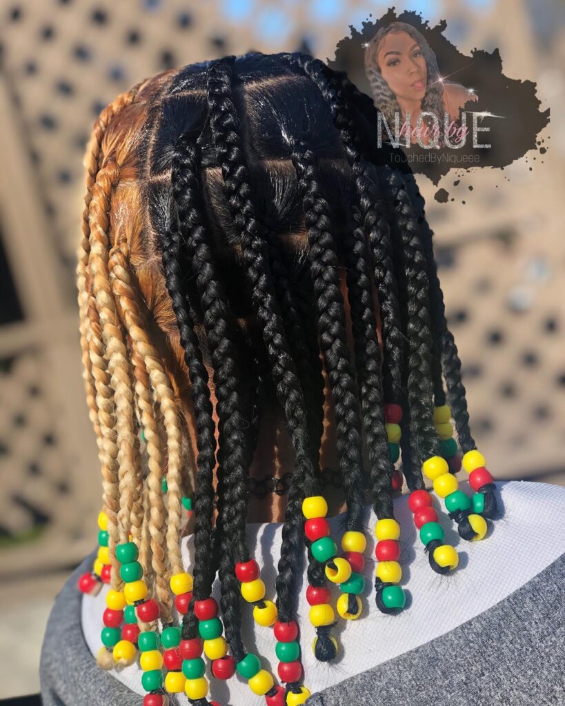 Medium box braids with black and blonde color blocking and colorful beads at the ends.
