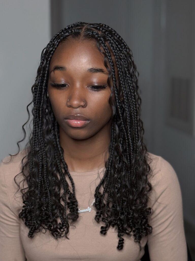 Short braids with tight curly ends creating a playful and textured style.