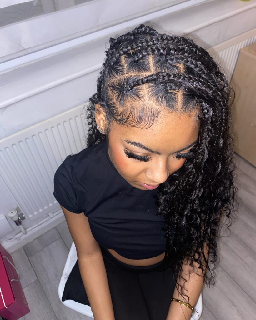 Curved tribal braids with detailed parting and long curly ends.