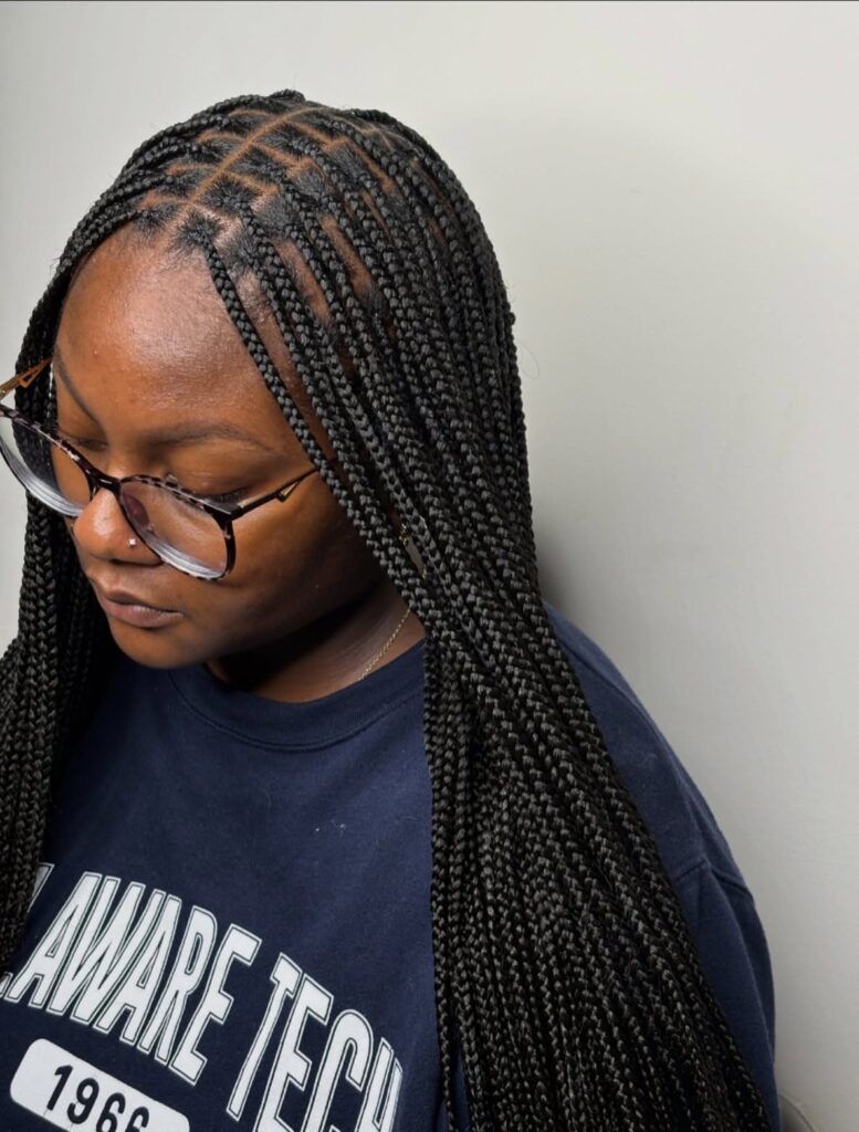 Long micro braids with neat parts and a sleek uniform finish.
