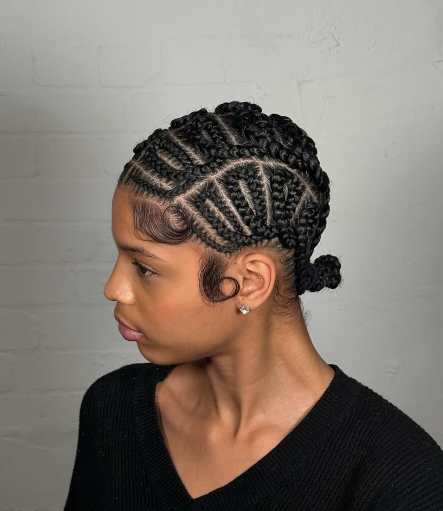 Intricate cornrow braids styled into a sleek low bun with defined patterns.