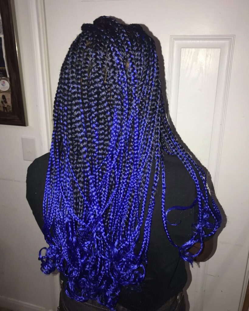 Deep blue braids with curled ends creating a soft and voluminous finish.