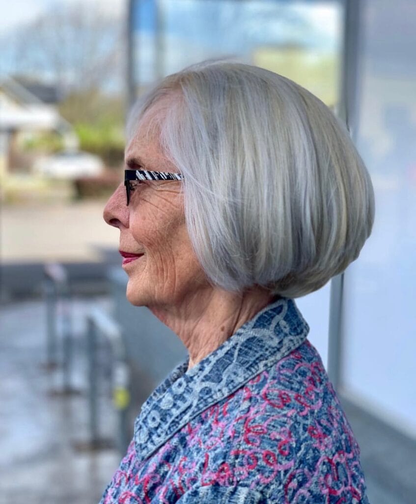 A woman with bright silver hair in a perfectly rounded chin length bob with a smooth voluminous finish.