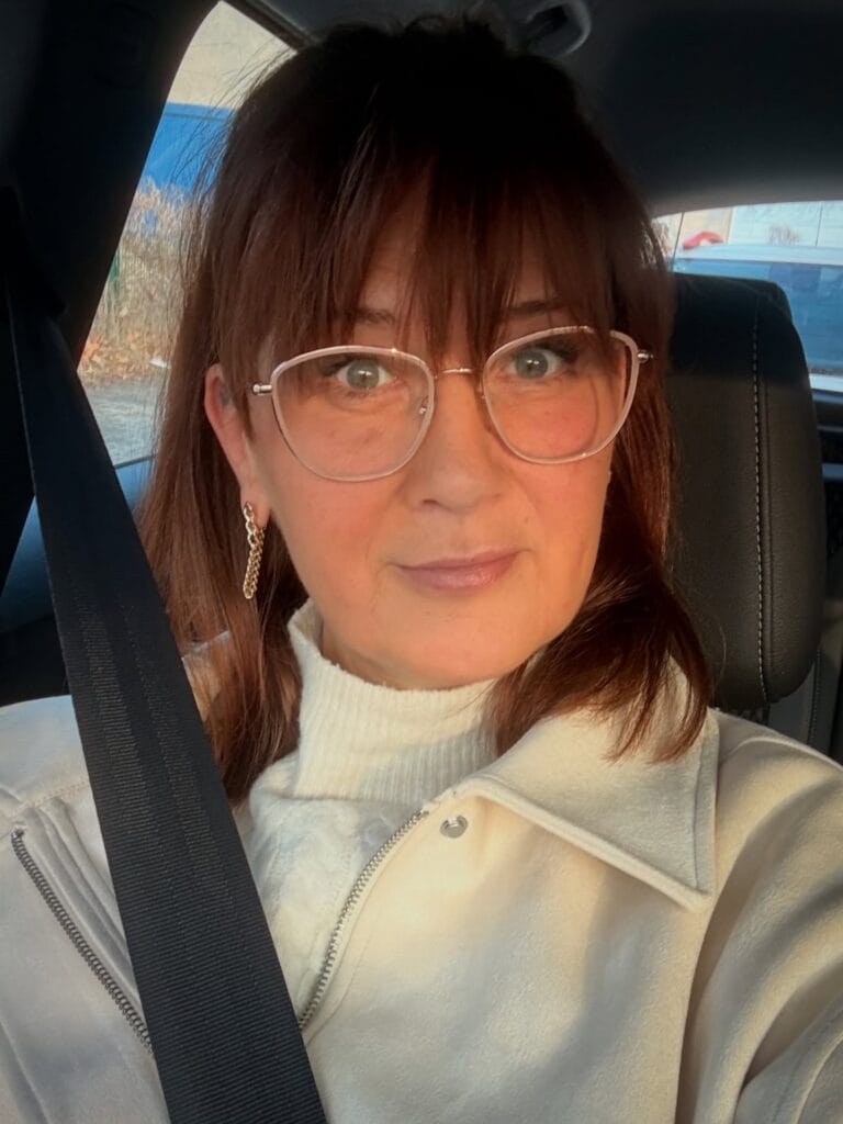 Shoulder length brunette hair with straight full bangs and smooth styling.