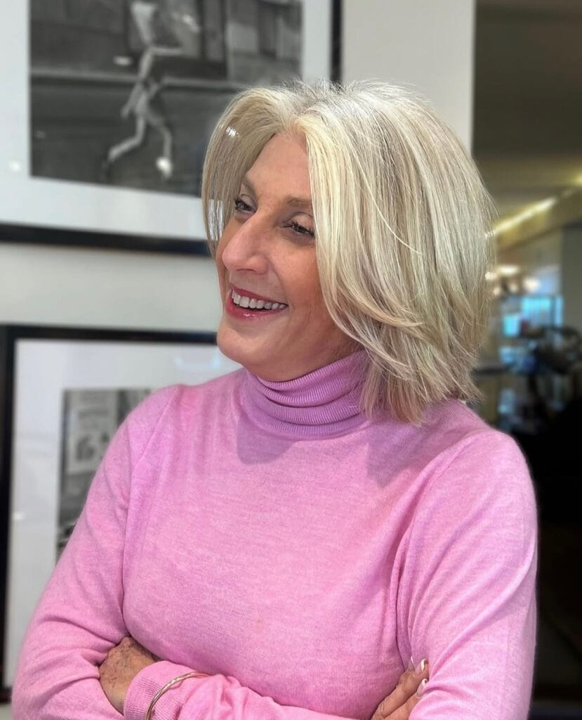 Chin length layered blonde bob with soft side swept bangs.