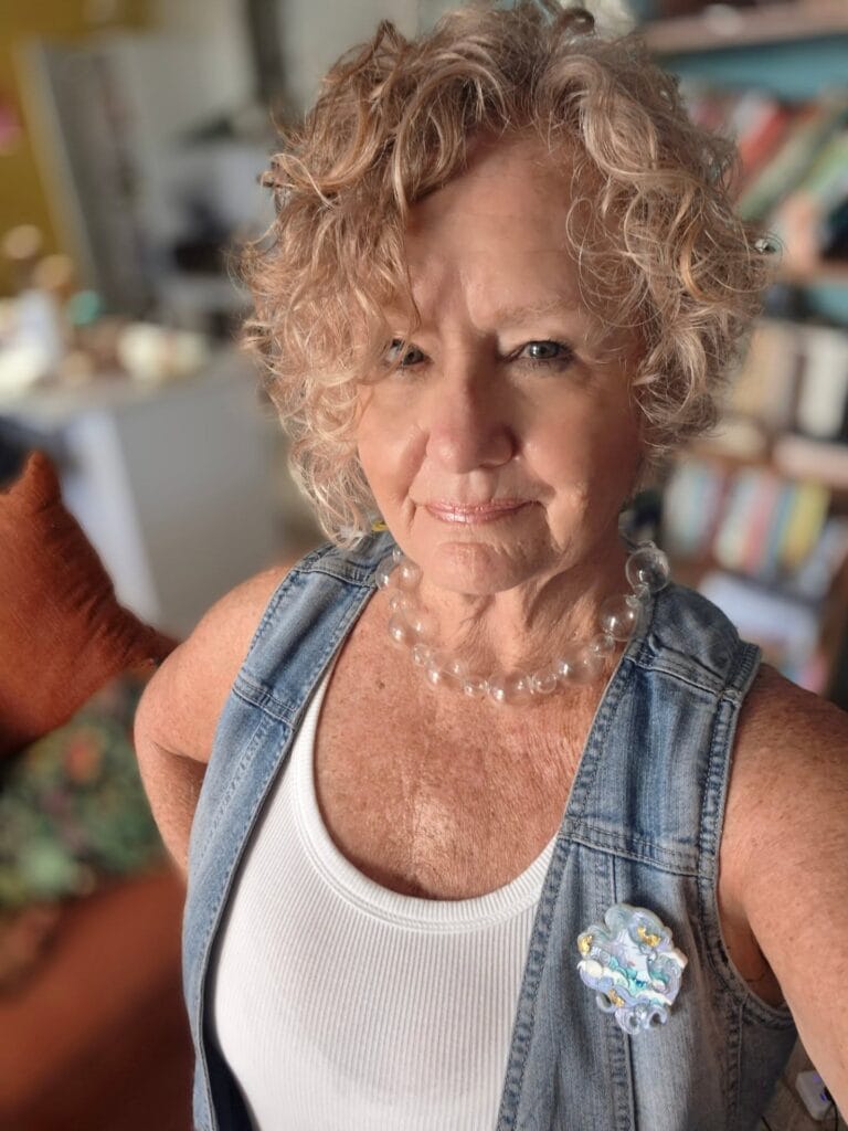 Short curly hairstyle with soft bangs and natural volume.