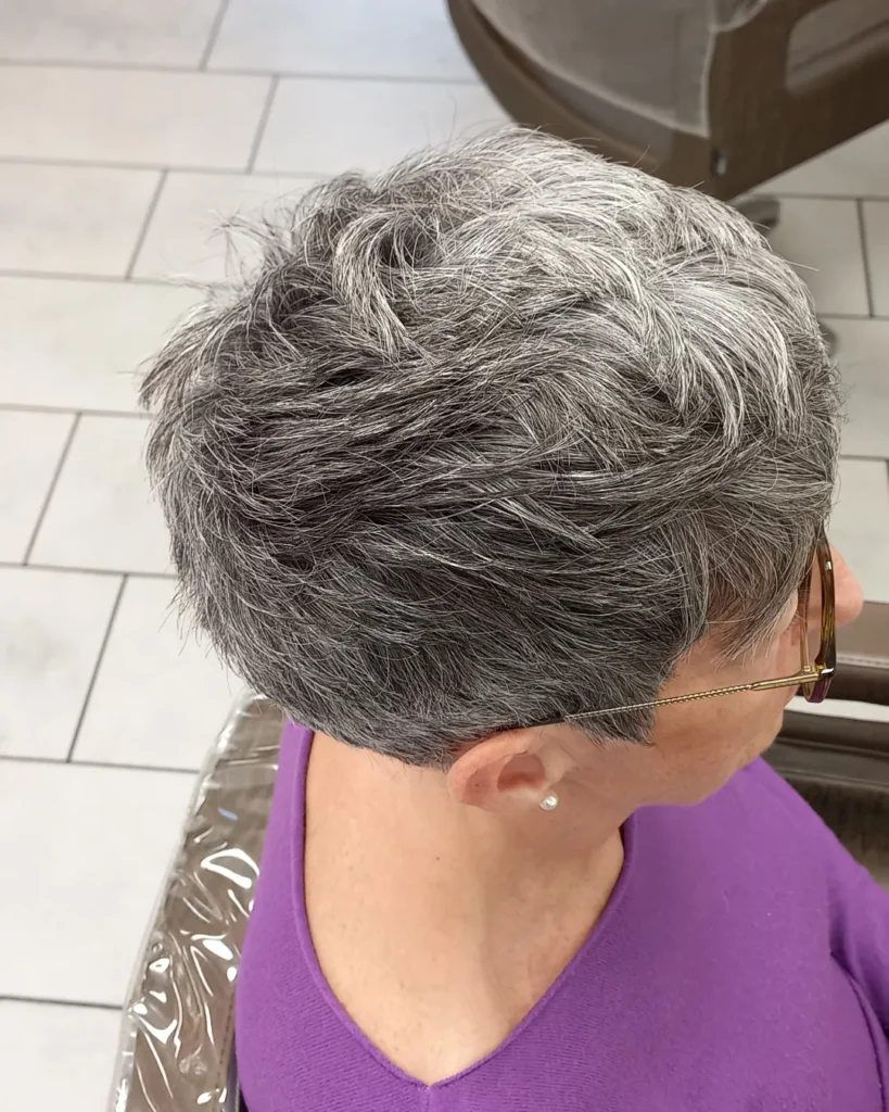 Short gray pixie haircut with textured layers and volume at the crown.