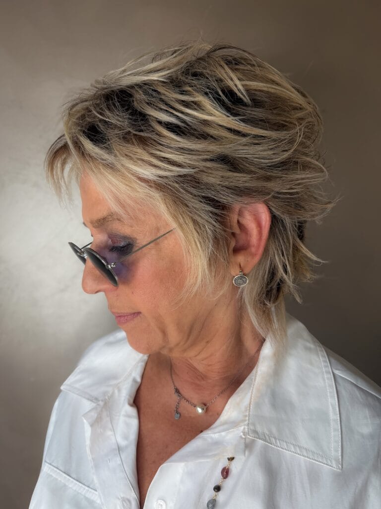 Short layered pixie haircut with volume at the crown and blonde highlights.