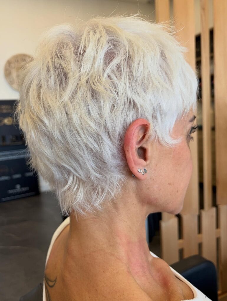Short white blonde pixie haircut with soft wispy layers and light texture.