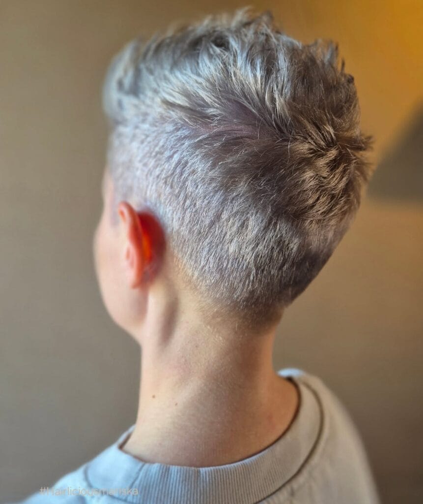 Short gray pixie haircut with an undercut and textured volume on top.