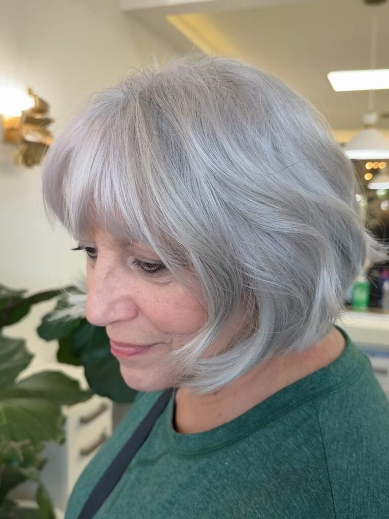 Short silver bob with soft layers and a wispy fringe framing the face.
