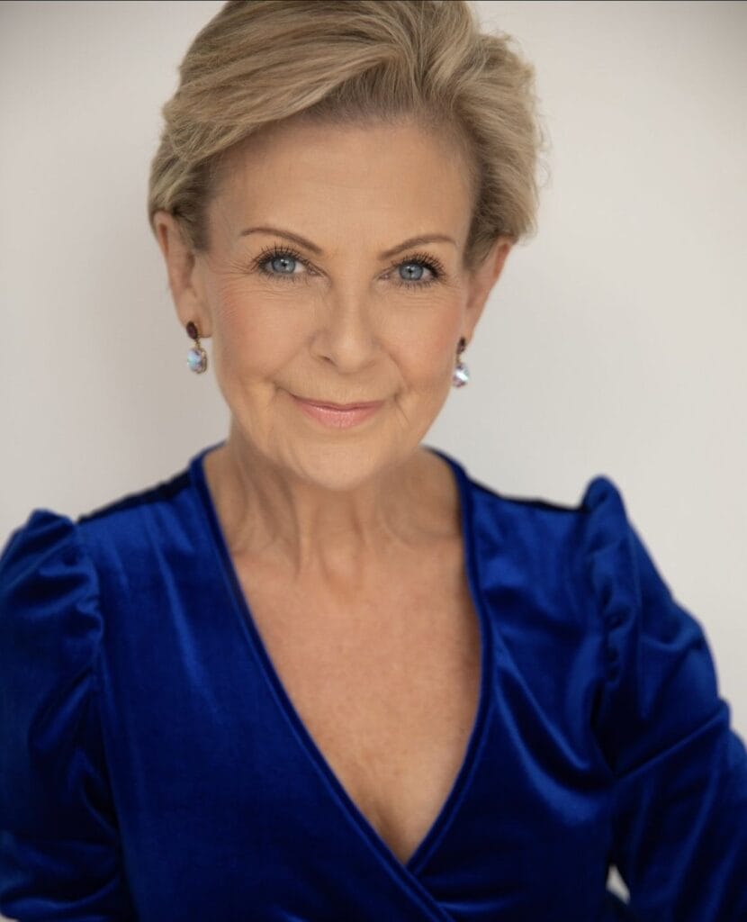 Short blonde pixie haircut with volume on top and a polished finish.