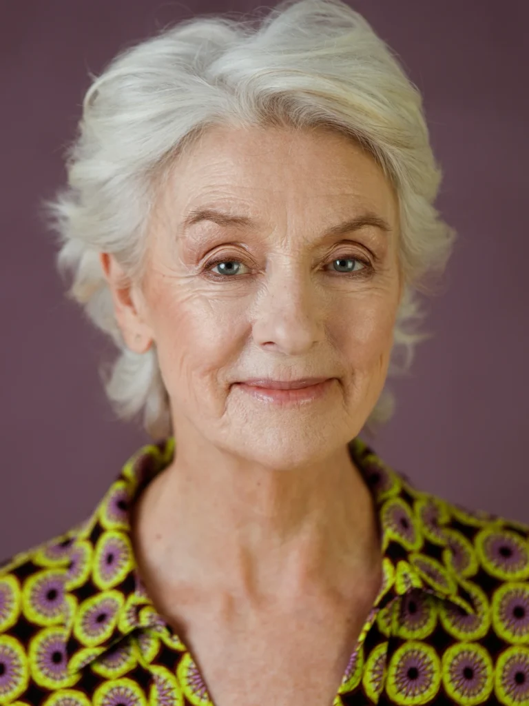 Short white pixie haircut with smooth layers and a sleek polished finish.