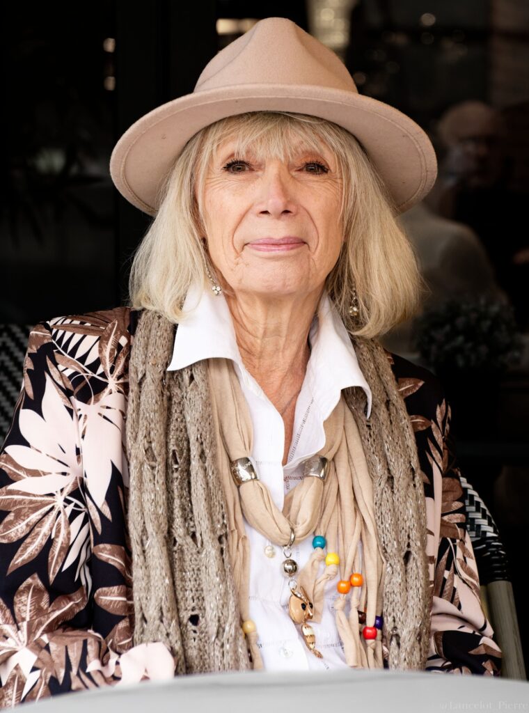 Long straight silver hair worn loose with a soft natural flow and a hat.