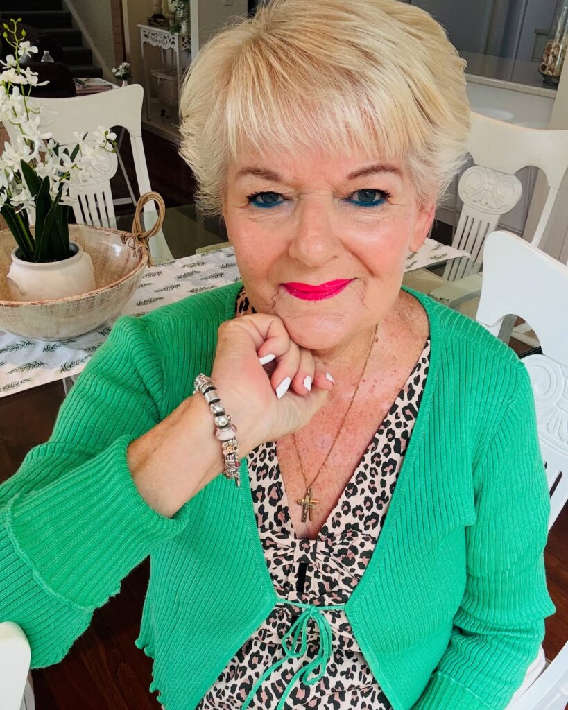 Short blonde cropped hairstyle with soft layers and a side swept fringe.