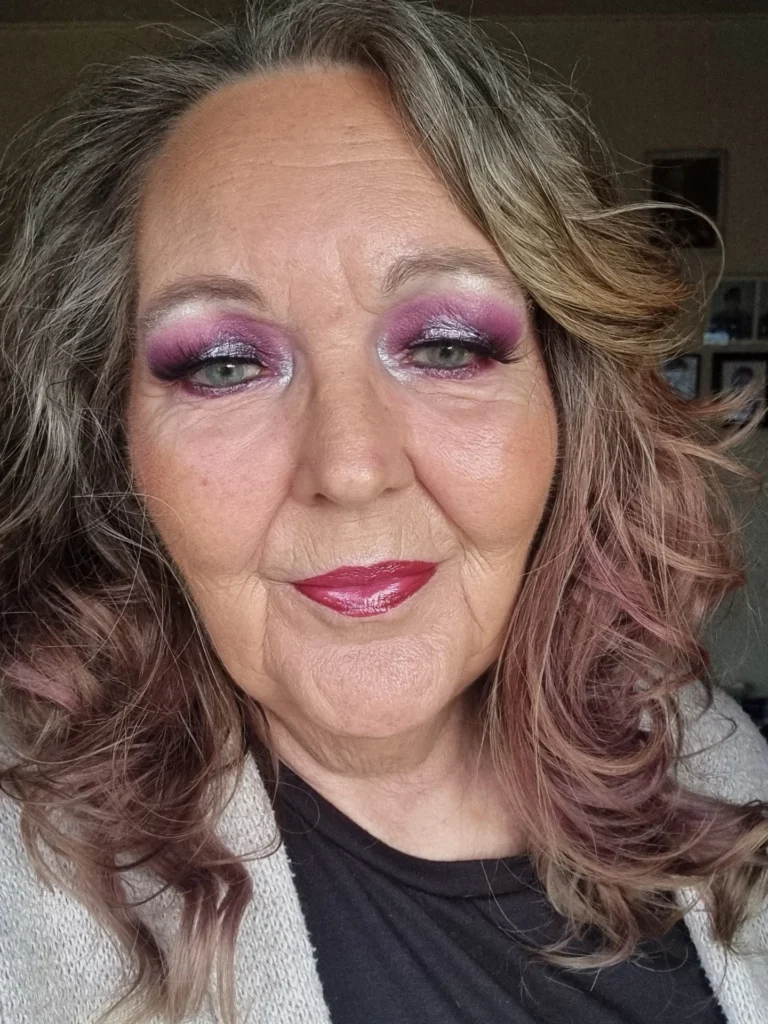 Medium-length layered wavy hair with volume and soft warm toned highlights.