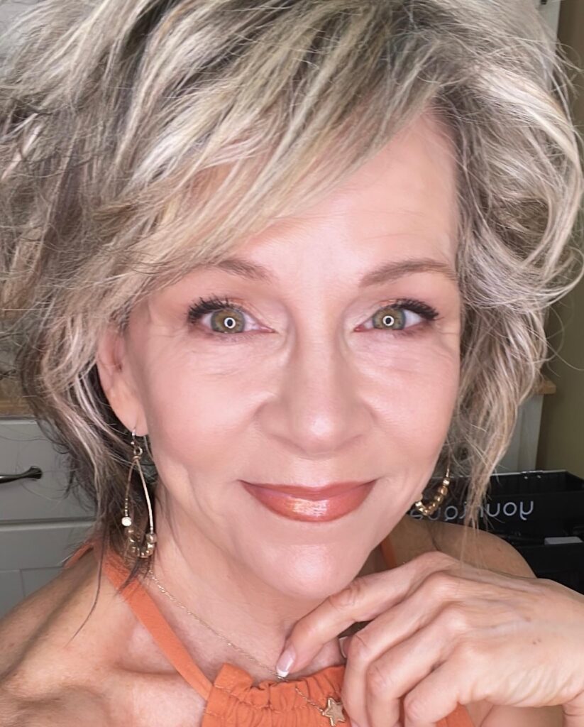 Short to medium blonde hair with soft feathered layers and light volume.