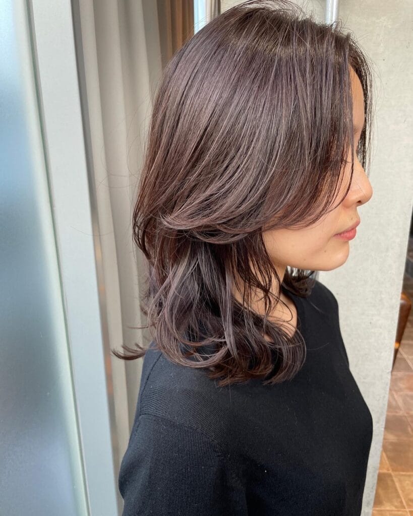 Medium length brown layered hairstyle with soft natural movement.