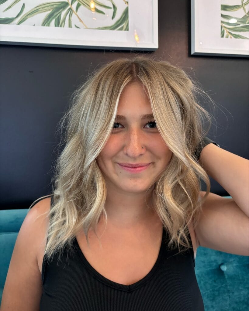 Medium length shag haircut with soft blonde waves and textured layers.