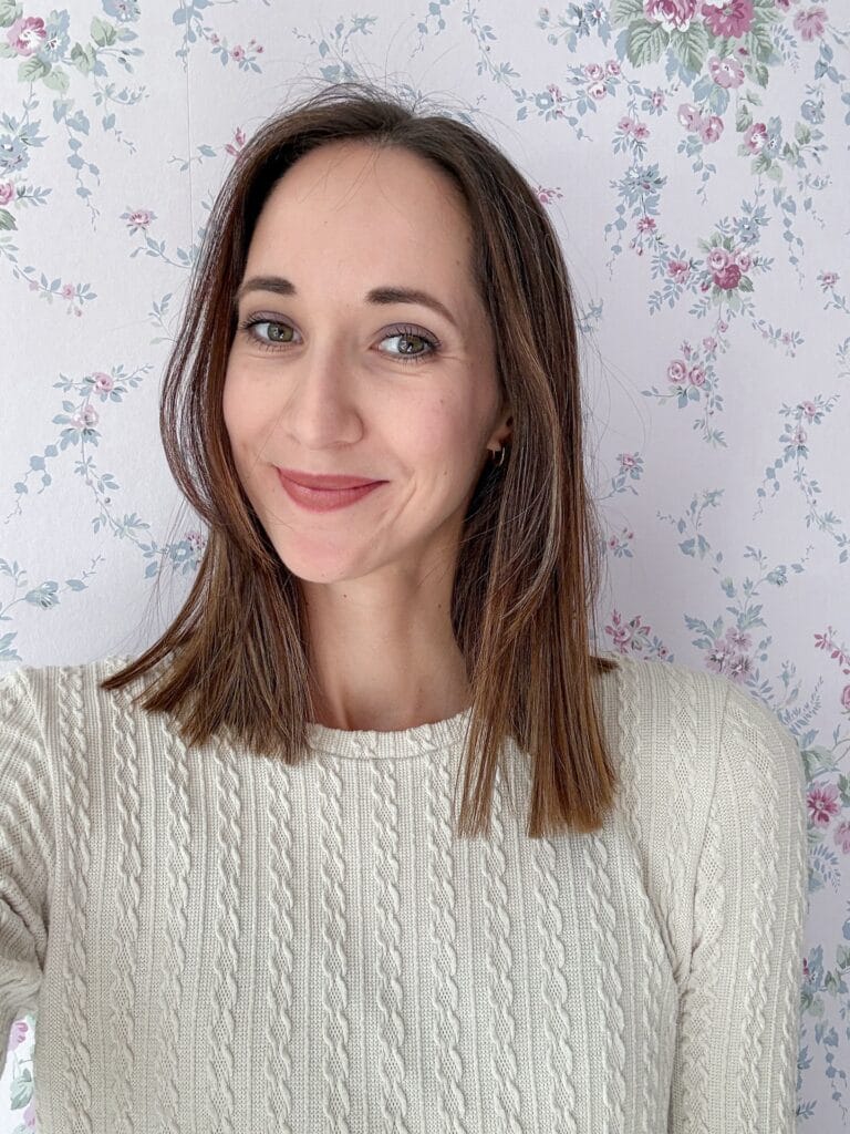 Medium length brunette hairstyle with blunt ends and soft face framing layers.