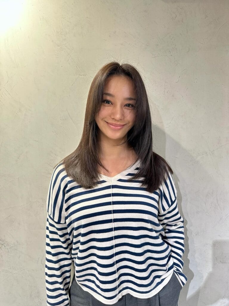 Medium length straight dark brown hairstyle with soft layered ends.