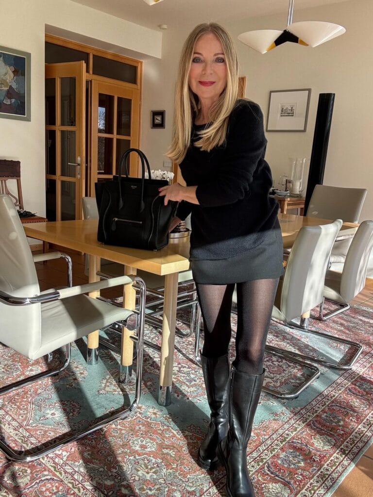 A woman with long straight blonde hair styled with soft layers and light volume at the roots.